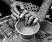 A potter turns a pot on a wheel