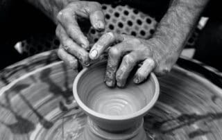 A potter turns a pot on a wheel