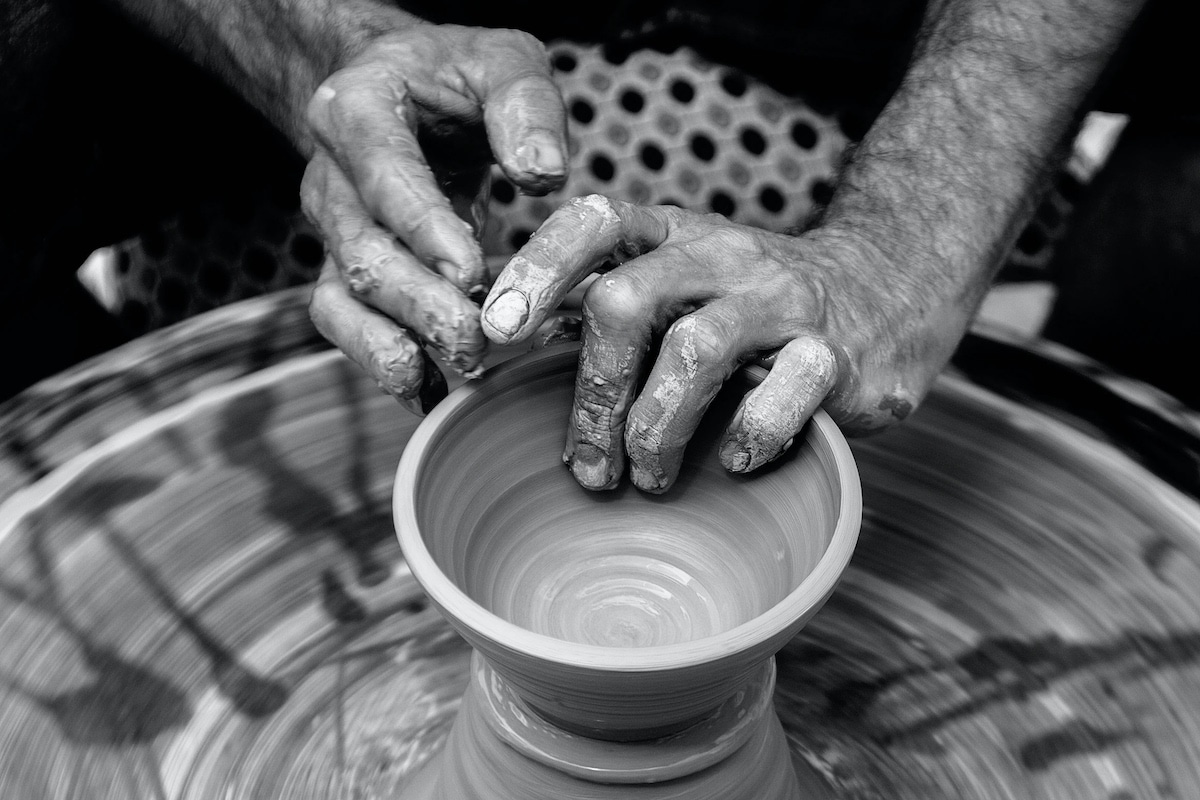 A potter turns a pot on a wheel